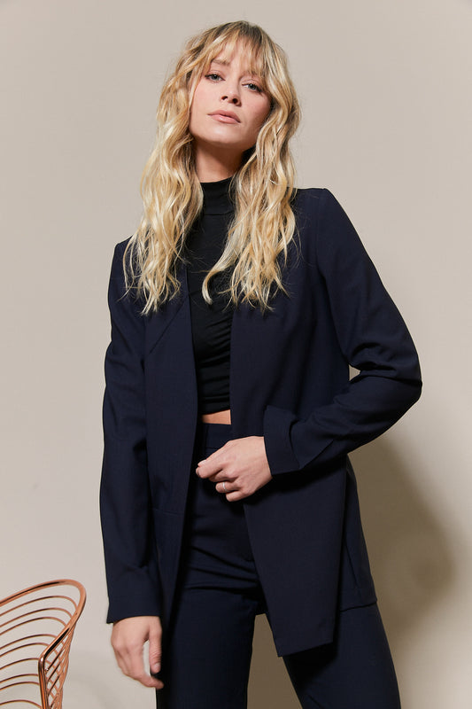 Femme portant le blazer Andrea de Jeanne L. Paris, un vêtement intemporel en laine éco-responsable, conçu en France. Parfait pour un look chic et moderne.